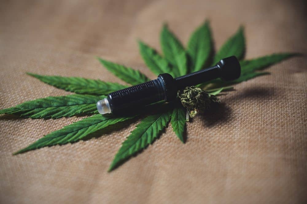 syringe on cannabis leaf