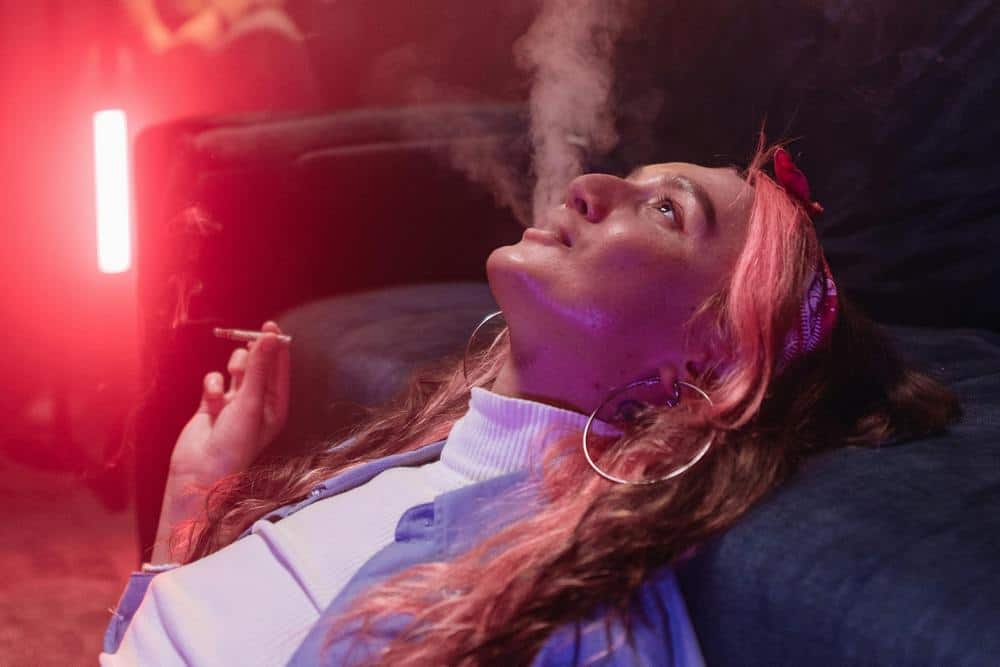 woman head back exhaling weed smoke